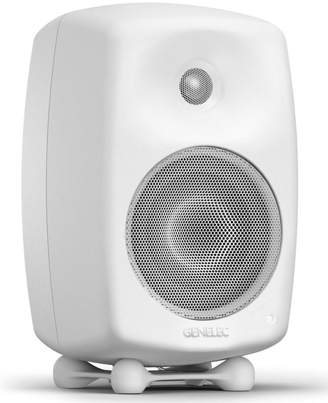 Valkoinen Genelec aktiivikaiutin, hyvin suojatut elementit, lapsi ja kissa turvallinen